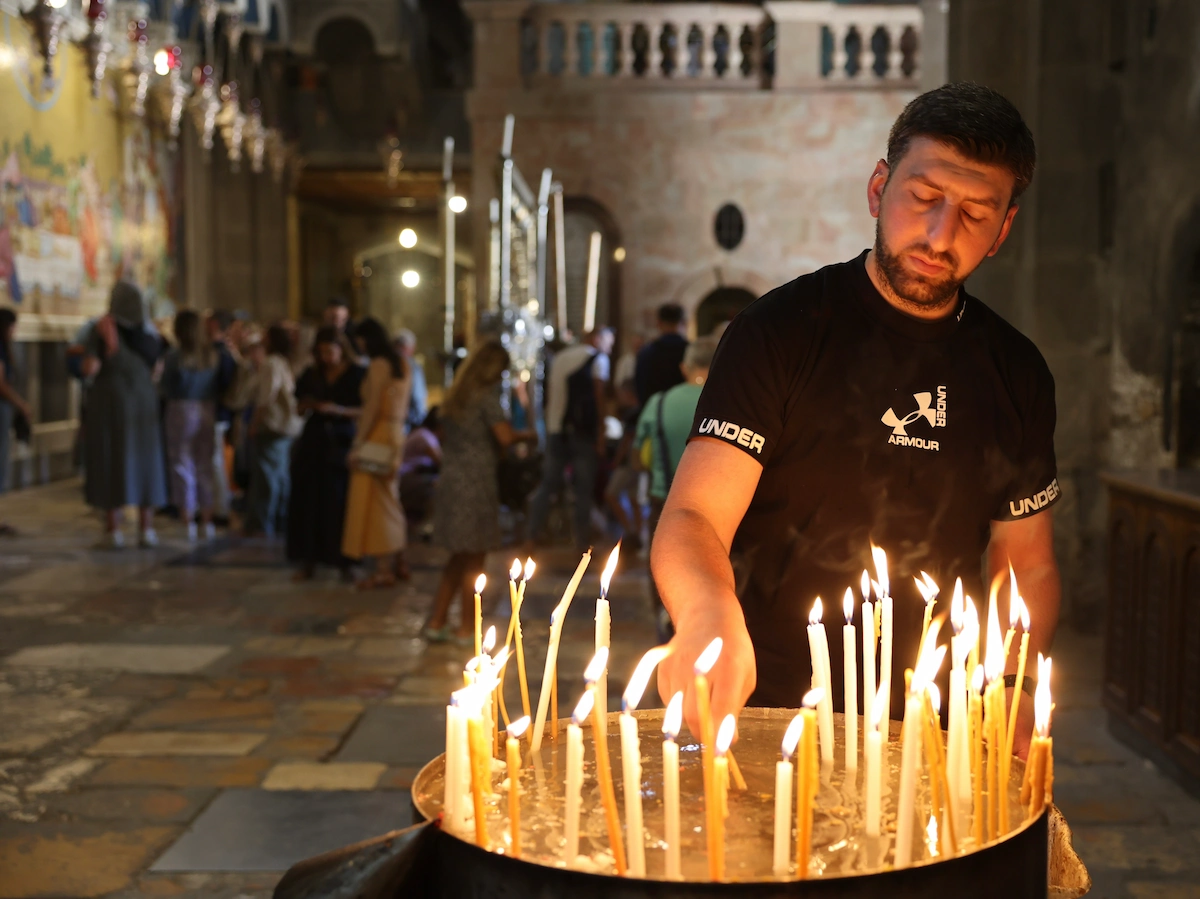 Man lighting candle at Church of the Holy Sepulchre, Jerusalem