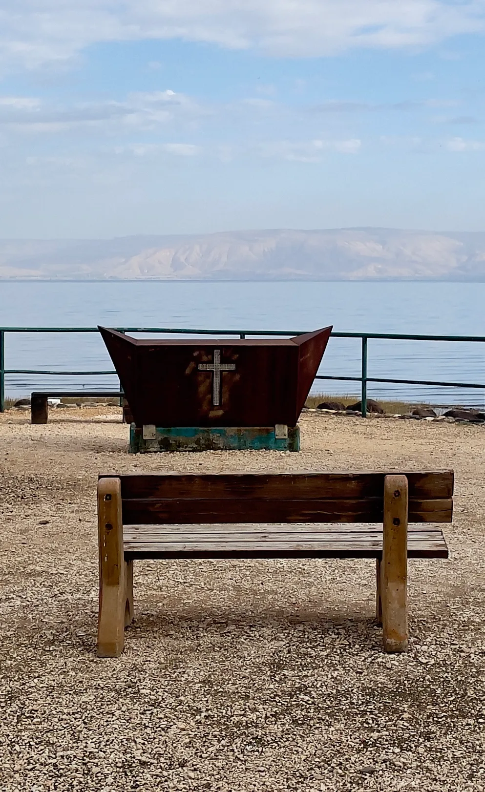 Bench and cross on the shore at Magdala, Sea of Galilee