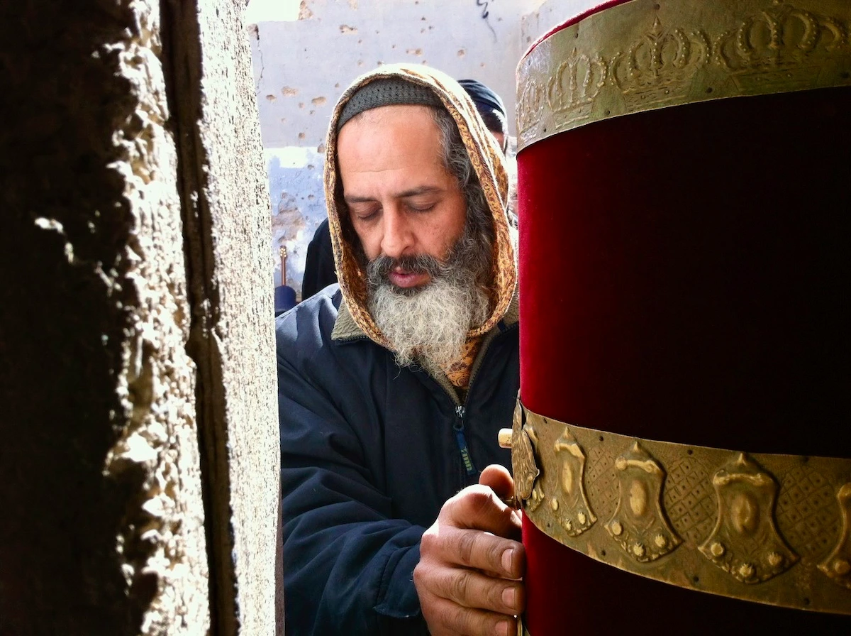 Man holding Torah scroll in the Judean Desert