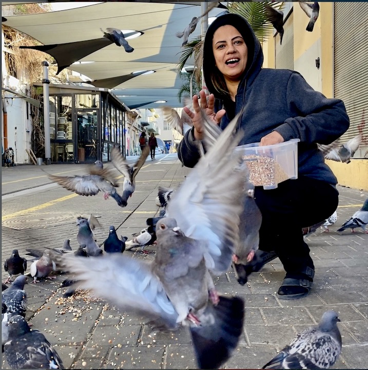 Woman feeding pigeons in Jaffa