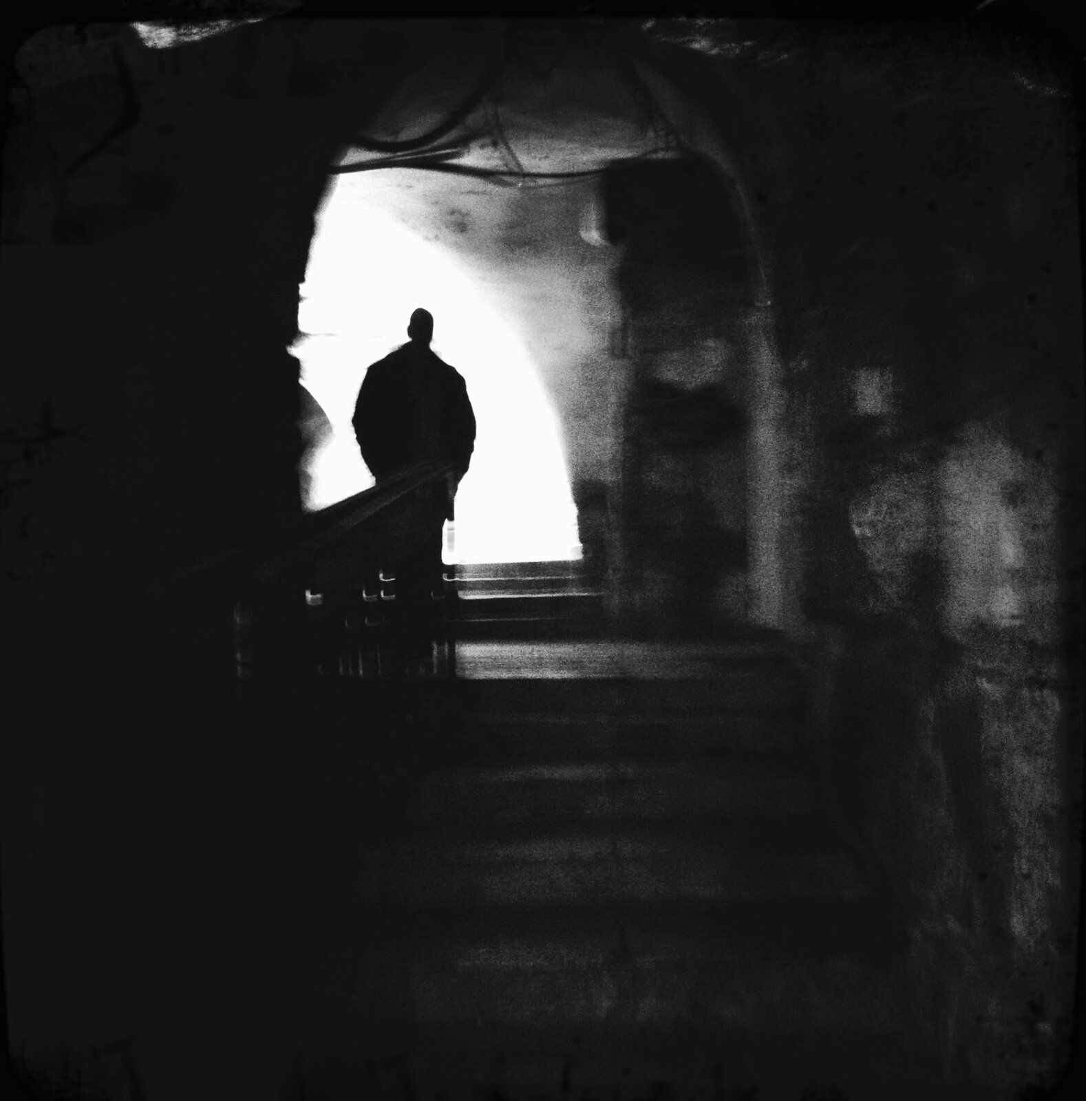Silhouette of a man climbing stone stairs toward the light, Old City, Jerusalem
