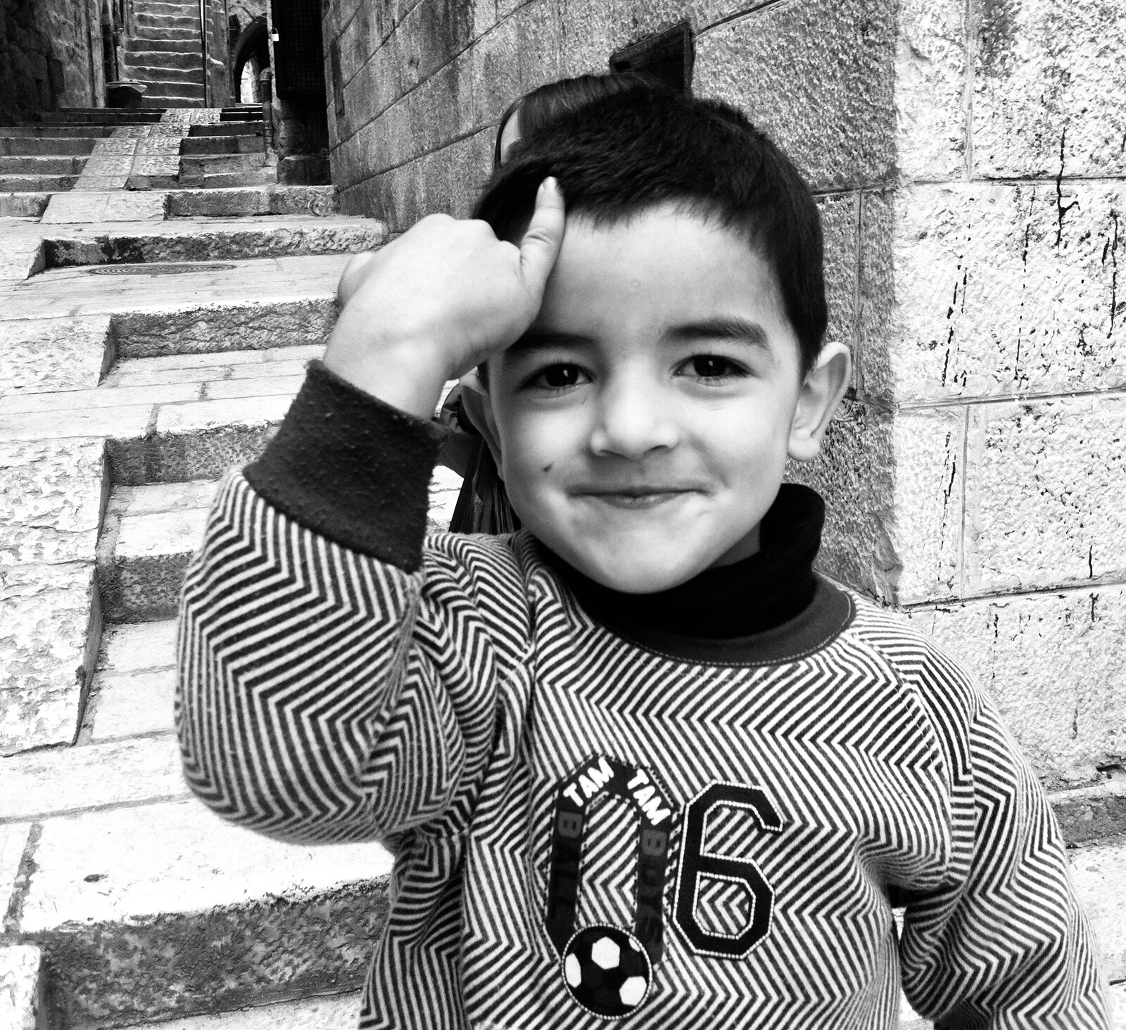 Portrait of a smiling boy on stone steps, Old City, Jerusalem