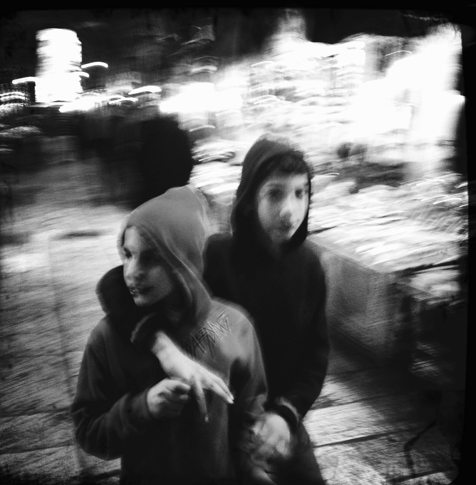 Two hooded children walking through the market at night, motion blur, Jerusalem