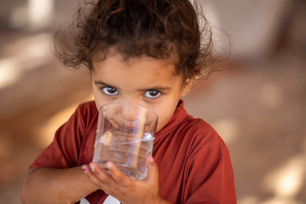 Bedouin girl drinking water in tent, Rashayda camp, Judean Desert