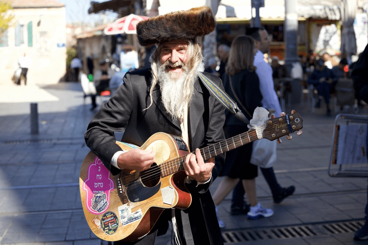 Hasidic street musician playing guitar in Jerusalem