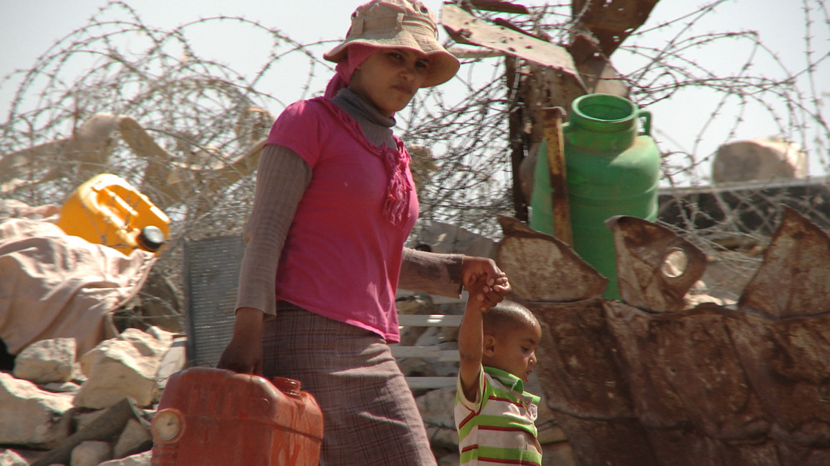 Woman carrying water with child